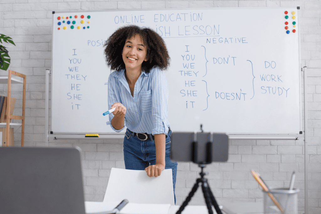 Young teacher smiling while teaching in front of a camera.