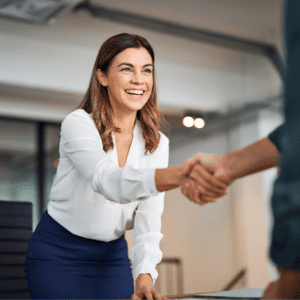 A woman understanding part-time employment policies for teachers shakes hands with a man in an office.